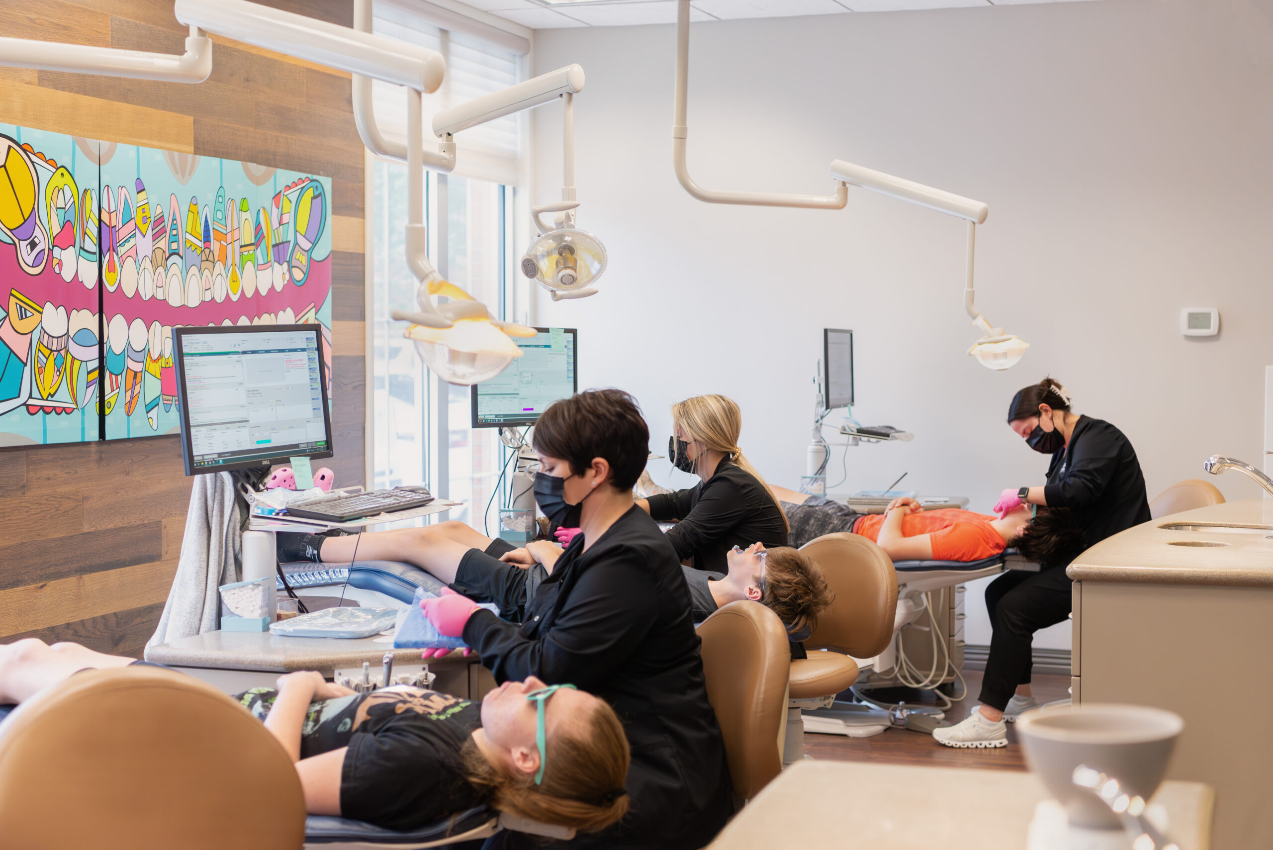 Orthodontic healthcare professionals treat child and teen patients in an orthodontic office.